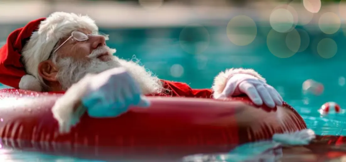 Père noêl sur une bouée dans une piscine